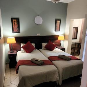 圣卢西亚莎娜朗佳山林小屋的一间卧室配有两张带红色枕头的床