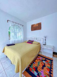 圣马科斯拉拉古纳El Castillo en el Lago Atitlán的卧室配有一张床,地板上铺有地毯