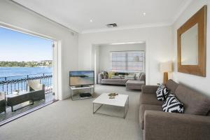 悉尼Balmoral Apt unbelievable views 1min walk to beach的带沙发、电视和桌子的客厅
