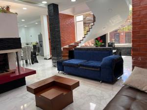基多Casa de Campo Guayllabamba的客厅设有蓝色的沙发和楼梯。