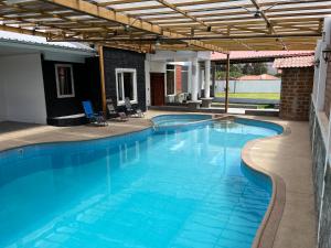 基多Casa de Campo Guayllabamba的一个带凉棚的大型蓝色游泳池