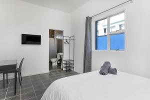 开普敦Inn & Out Express Sea Point的一间卧室配有一张床、一张书桌和一个窗户。