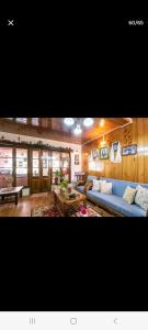 大吉岭Little Singamari Home Stay的客厅配有蓝色的沙发和桌子