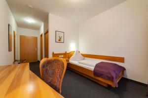 俄伦比斯费佛达尔旅馆酒店的配有一张床和一把椅子的酒店客房