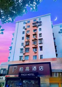 广州Paco Hotel Tianhe Coach Terminal Metro Guangzhou的前面有标志的高楼