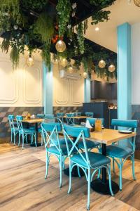 新德里鲁帕马酒店的一间配备有蓝色桌椅的用餐室