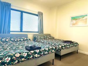 阿德莱德Bundled Bliss 2 bedroom Condo in Adelaide CBD的一间卧室设有两张床和窗户。