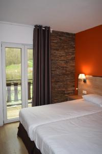 阿林萨尔HOTEL VICTORIA的一间卧室设有一张大床和一个窗户。