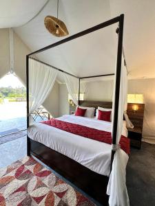 SomvārpetRedberry's Luxury Stay的一间卧室配有一张带红色枕头的天蓬床