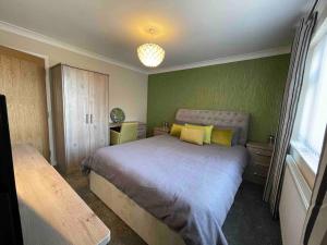 Lincolnshirelodge in the heart of Bourne的一间卧室配有一张带黄色枕头的大床