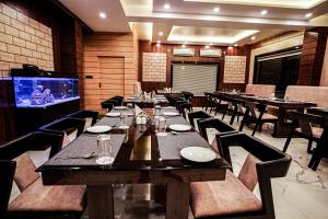 曼达莫尼Gogol Beach Resort的一间带桌椅和电视的用餐室