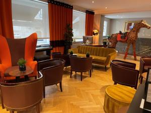 斯特拉斯堡Maison LUTETIA R的酒店大堂设有椅子和长颈鹿雕像