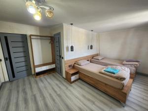 杜尚别绿屋旅舍的配有2张床的客房,设有2扇门和木地板