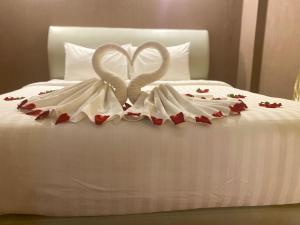 万象Sinakhone Vientiane Hotel的一张有两只白天鹅的睡床,看起来像心灵