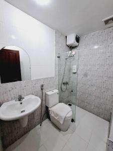 万象Sinakhone Vientiane Hotel的浴室配有卫生间、盥洗盆和淋浴。
