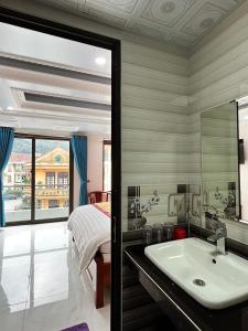 萨帕Quoc Tuan Hotel Sapa的一间带水槽、床和镜子的浴室