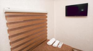 甘贾NM Butik Hotel的客房设有木墙和平面电视。