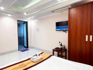 萨帕Quoc Tuan Hotel Sapa的卧室配有一张床,墙上配有电视。