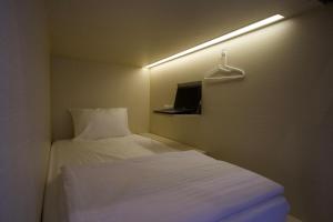沙努尔Aiwan Hostel & Luggage storage的小房间,配有床和衣架