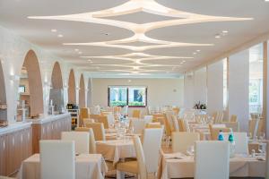 康特港Hotel Portoconte的用餐室配有白色的桌子和白色的椅子