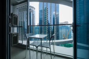 马尼拉Cozy 1BR Apartment in Manila, BGC, with Balcony & Pool的市景阳台配有桌椅