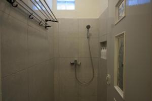 沙努尔Aiwan Hostel & Luggage storage的带淋浴喷头的浴室