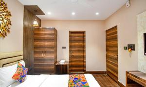 加尔各答FabHotel Jalsa Residency New Town的一间卧室配有一张床和一扇木门