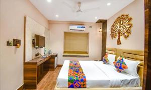 加尔各答FabHotel Jalsa Residency New Town的一间卧室配有一张带书桌和水槽的床。