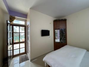 西姆拉Zu-Zu Hostels的一间卧室设有一张床和一个窗口