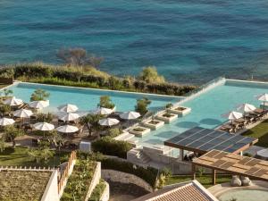 阿克罗蒂Lesante Cape Resort & Villas - The Leading Hotels of the World的享有带遮阳伞的泳池和大海的空中景致