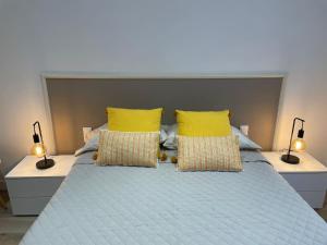 科尔内拉德罗布雷加特Nice Apartment 2 Bedrooms Well Connected的一间卧室配有蓝色的床和黄色枕头