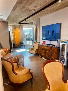 扎鲁亚斯Zarautz Surf House的客厅配有椅子和大屏幕电视
