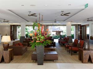 棕榈湾铂尔曼棕榈湾海神庙度假酒店&水疗中心的一个带沙发和椅子的酒店大堂