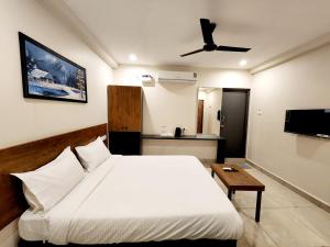 蒂鲁帕蒂Hotel Park Varaahi的卧室配有白色的床和吊扇