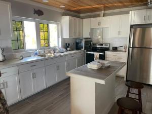 总督港Winfield Manor home的厨房配有白色橱柜和不锈钢用具