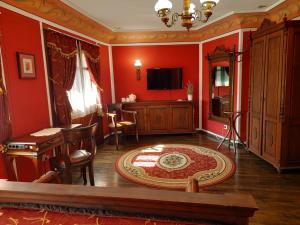 普罗夫迪夫文艺复兴广场家庭酒店的客厅设有红色的墙壁和桌椅