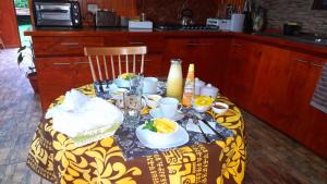 安加罗阿Hostal Makohe Rapa Nui的一张桌子,上面有黄色和白色的桌布,上面有食物