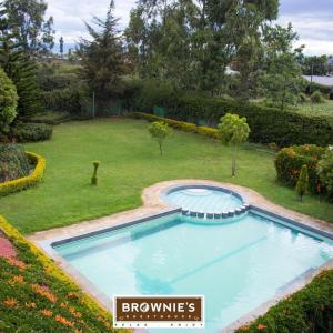 纳库鲁Brownies Deluxe的庭院里的一个大型游泳池,有院子