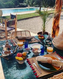 索维拉Villa Des Arganiers的一张桌子,上面放着食物和水果盘