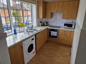 吉尔福德Millmead Apartment in central Guildford with parking的一个带水槽和洗碗机的厨房