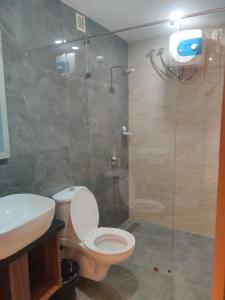 海得拉巴Grand Manor Suites的一间带卫生间和玻璃淋浴间的浴室