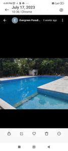 蓬蒂切里Sri Sai Farm House的一张蓝色游泳池的照片,上面有一个网站