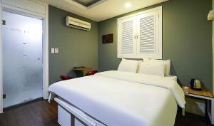 富川市Motel Lamant的卧室设有一张白色大床和一扇窗户。