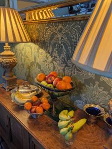 达多山墙奢华住宿加早餐旅馆的一张桌子,上面放着一碗水果和一盏灯