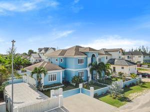 拿骚Blu Diamond Luxury Estate的一座种植了棕榈树和房屋的大型蓝色房屋