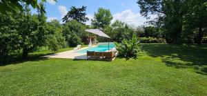 贝尔热拉克Au séchoir à Tabac的庭院内一个带长凳和遮阳伞的游泳池