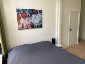 布雷达Mastbos Guesthouse Breda的卧室配有一张床,墙上挂有绘画作品