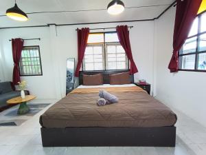 奈扬海滩THE NAIYANGHOUSE的一间卧室配有一张带红色窗帘的大床
