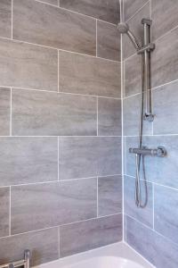 BarrasfordCosy Northumbrian Cottage的带淋浴的浴室(带瓷砖墙)
