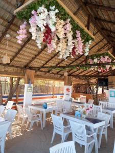 蓬塔露奇亚La Isla Bonita的餐厅设有桌椅,天花板上挂着鲜花